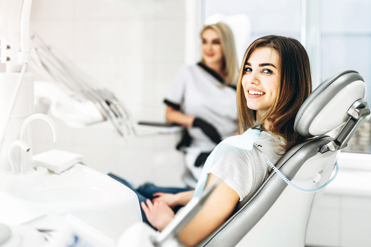 female dentist making examination and treatment for young female patient in dental clinic